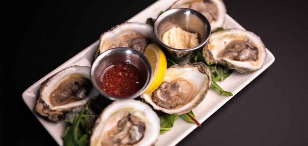 Plate of Pink Moon oysters paired with sparkling rosé on The Tasting Room patio