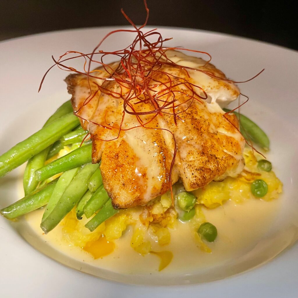 Pan-seared red grouper served with crab risotto, green beans, and prosecco beurre blanc at The Tasting Room in Traverse City