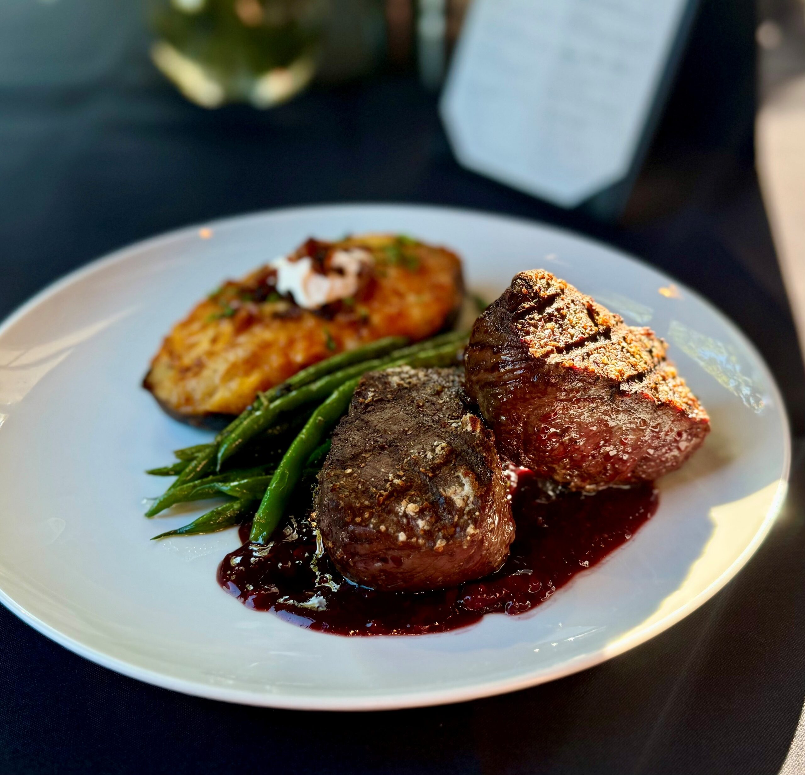 Elk strip loin with blackberry demi, twice-baked potato, and pesto green beans at The Tasting Room in Traverse City