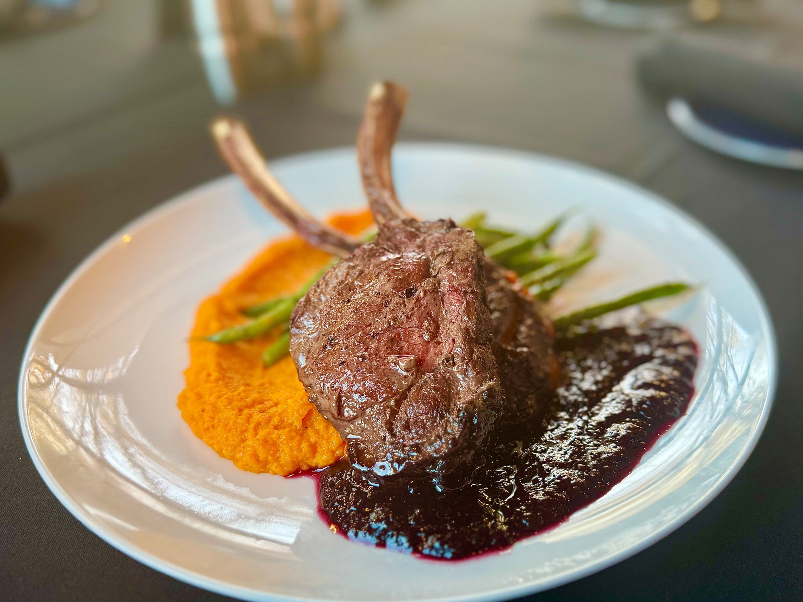 Venison loin chops with carrot–ginger purée, blueberry–balsamic reduction, and pesto green beans at The Tasting Room in Traverse City.