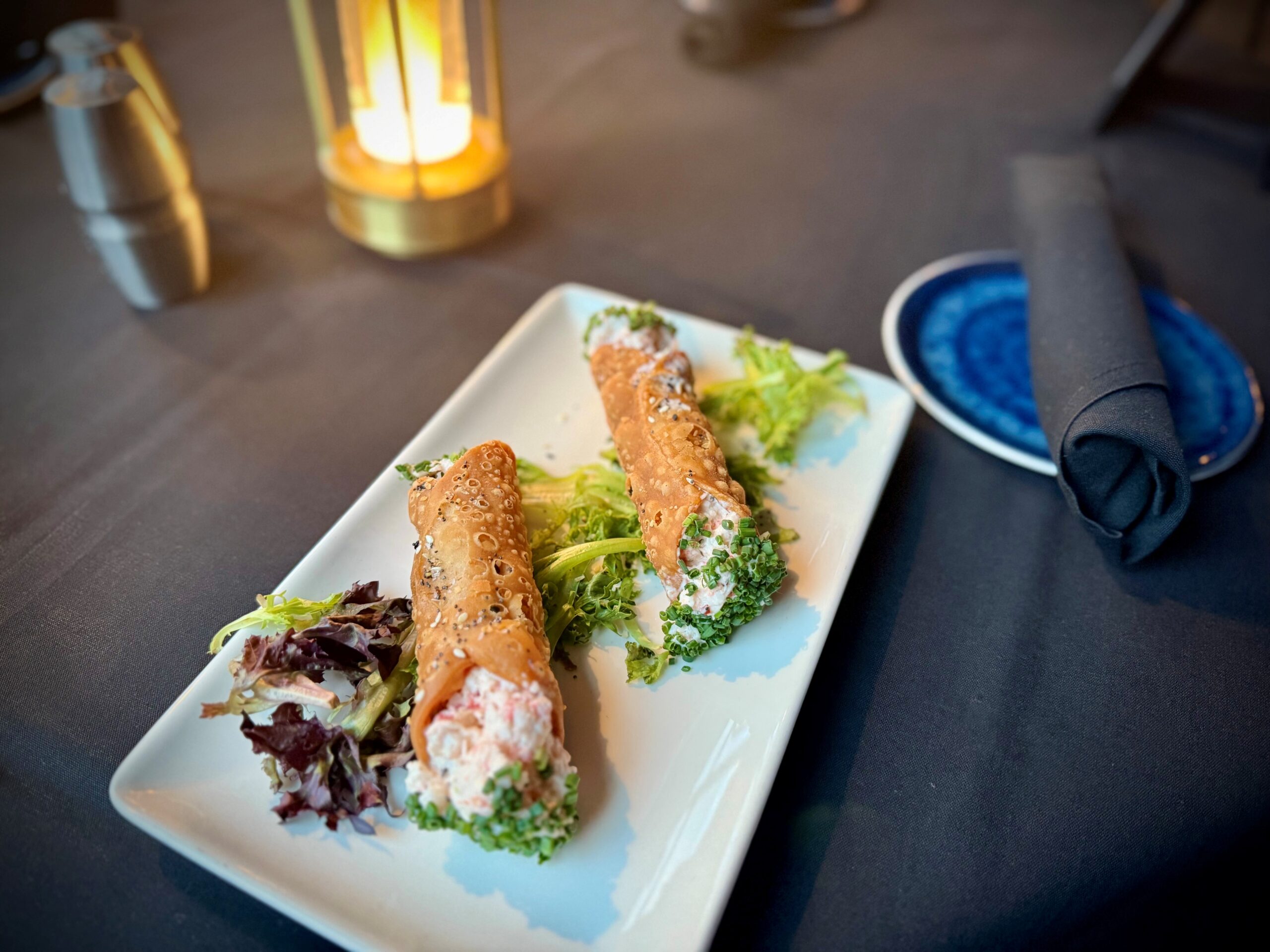 Chilled lobster salad served in a crisp sesame cannoli shell with fresh herbs and greens at The Tasting Room in Traverse City.