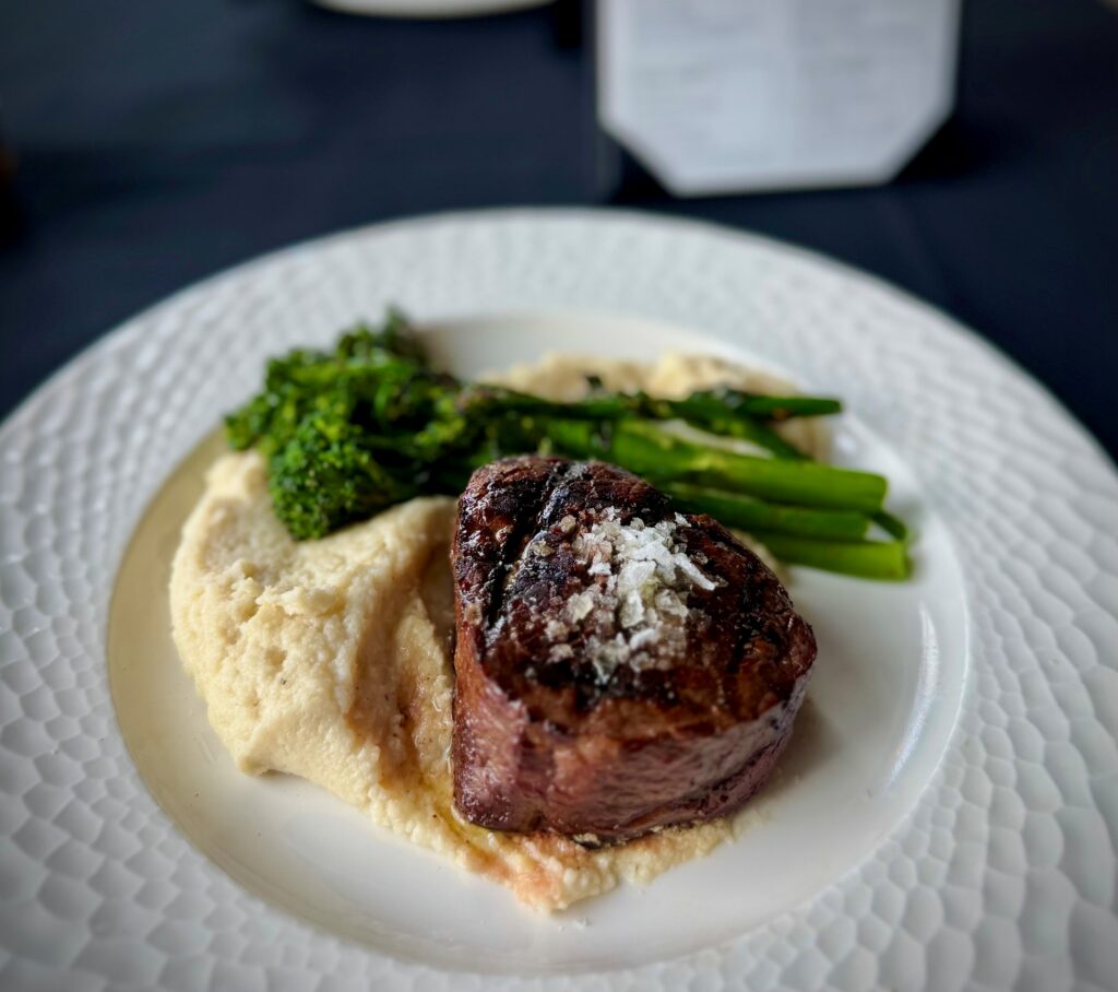 Kuro Wagyu tenderloin with grilled broccolini, cauliflower mash, and truffle peppercorn béarnaise at The Tasting Room in Traverse City