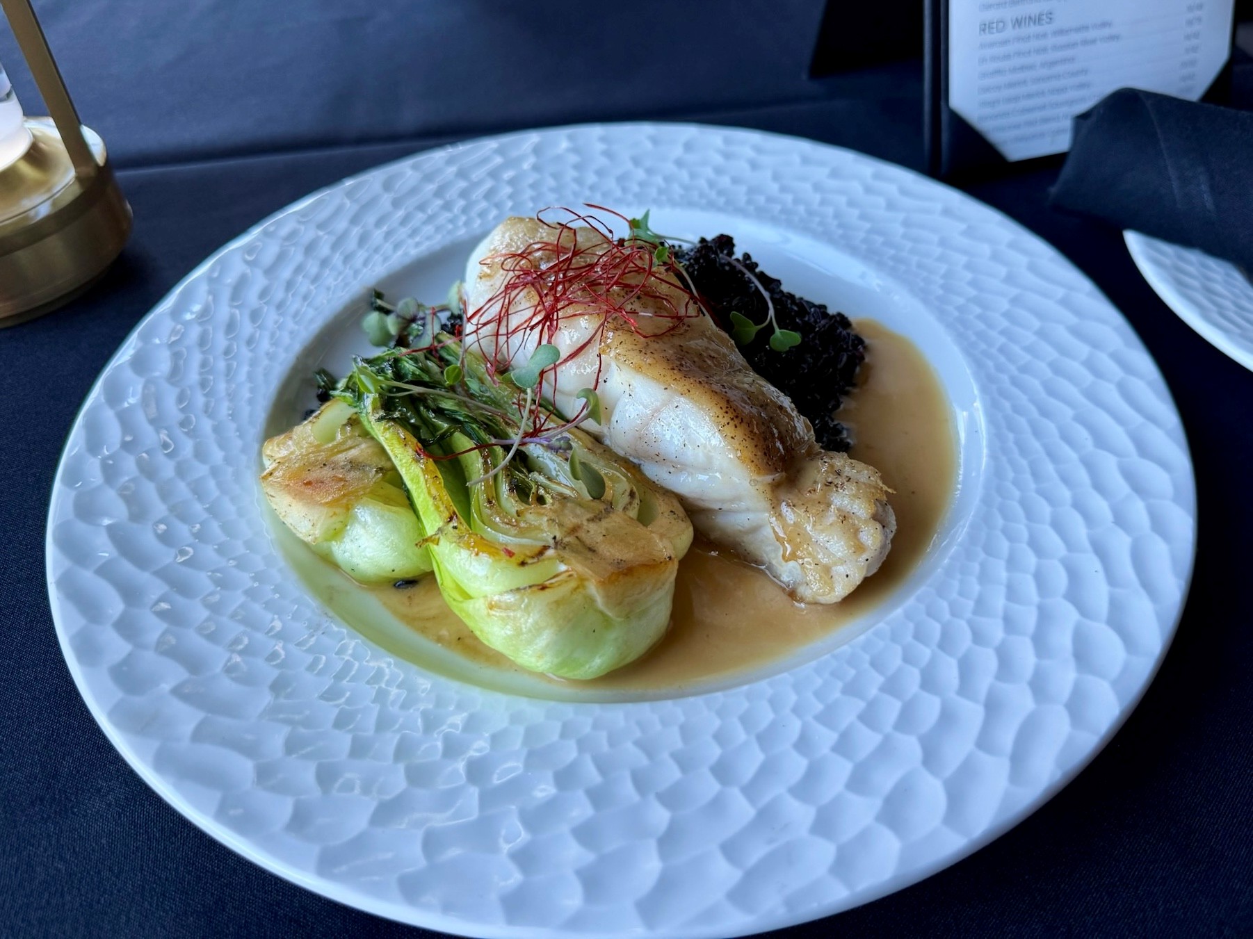 Red grouper with black rice pilaf, braised bok choy, and red miso beurre blanc at Cellar & Flame in Traverse City